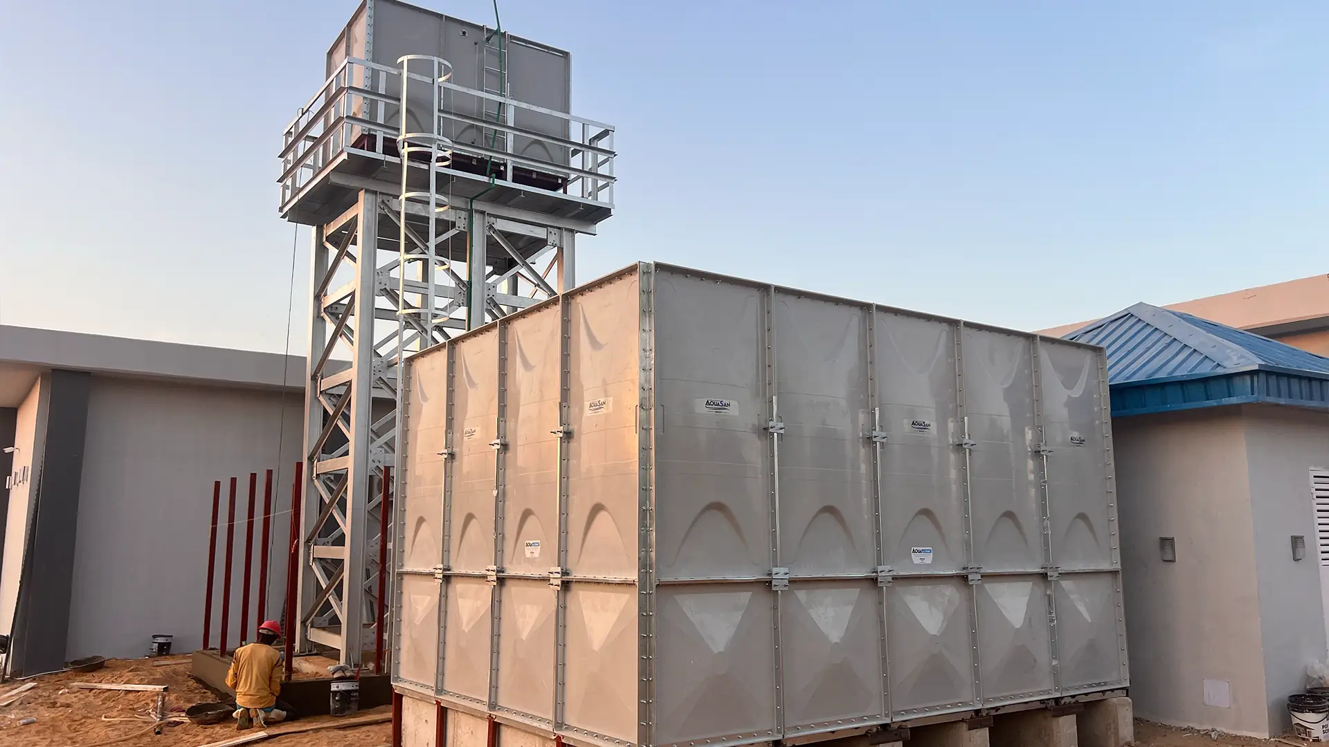 Réservoirs d’eau modulaires à panneaux gris installés sur une tour en acier et au sol